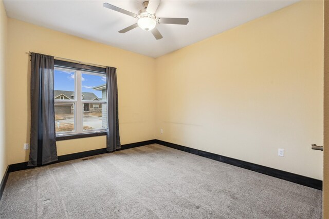 spare room featuring carpet, baseboards, and ceiling fan