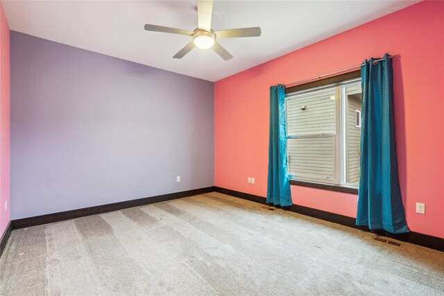 carpeted empty room with visible vents, ceiling fan, and baseboards