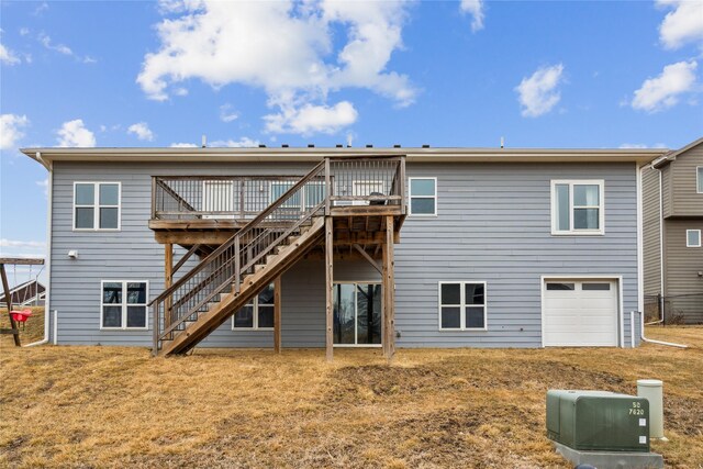 back of house featuring a deck, stairway, a lawn, and a garage