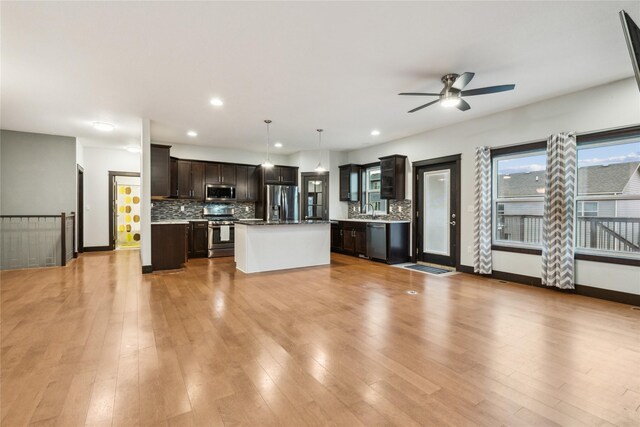 kitchen with light wood finished floors, stainless steel appliances, and tasteful backsplash