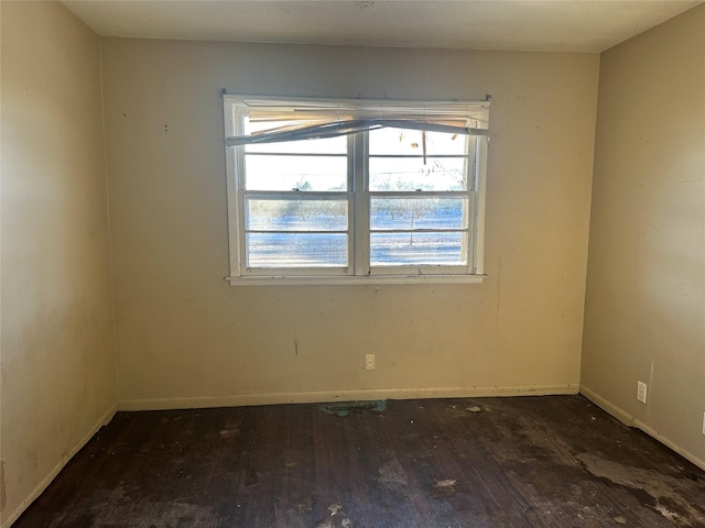 spare room featuring hardwood / wood-style floors and baseboards