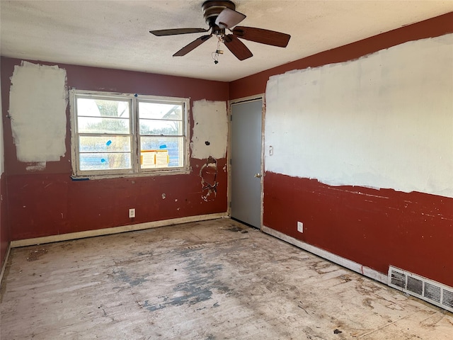 empty room featuring baseboards, visible vents, and ceiling fan