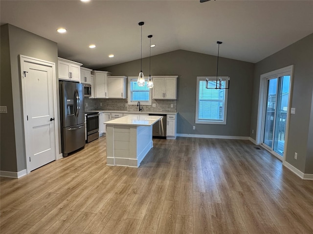 kitchen with light wood-type flooring, a sink, white cabinetry, appliances with stainless steel finishes, and light countertops