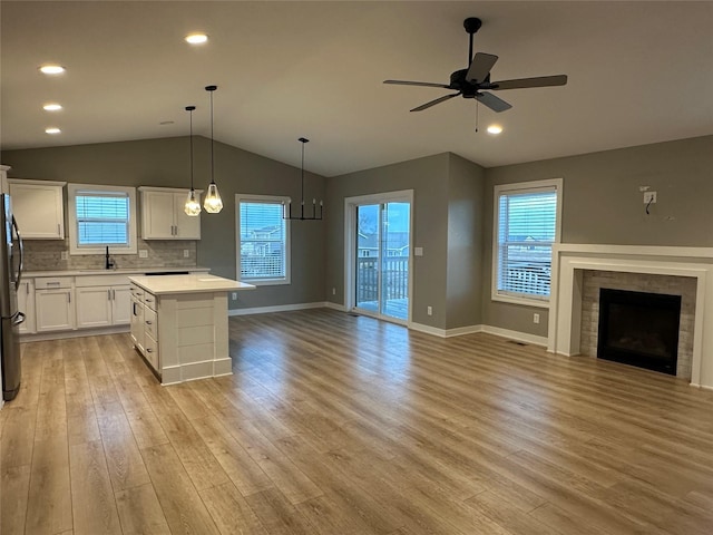 kitchen featuring light wood-style flooring, freestanding refrigerator, ceiling fan, a sink, and open floor plan