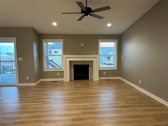 unfurnished living room featuring baseboards, light wood-style floors, a healthy amount of sunlight, and ceiling fan