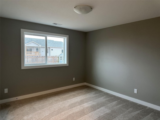 unfurnished room with baseboards, visible vents, and carpet floors