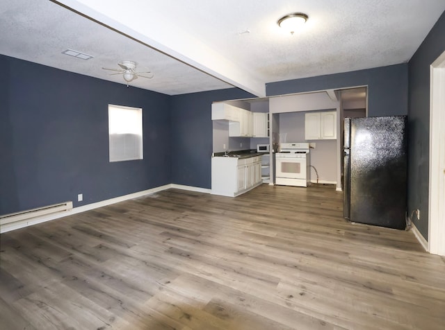 kitchen with beam ceiling, dark wood-type flooring, a sink, white appliances, and baseboard heating