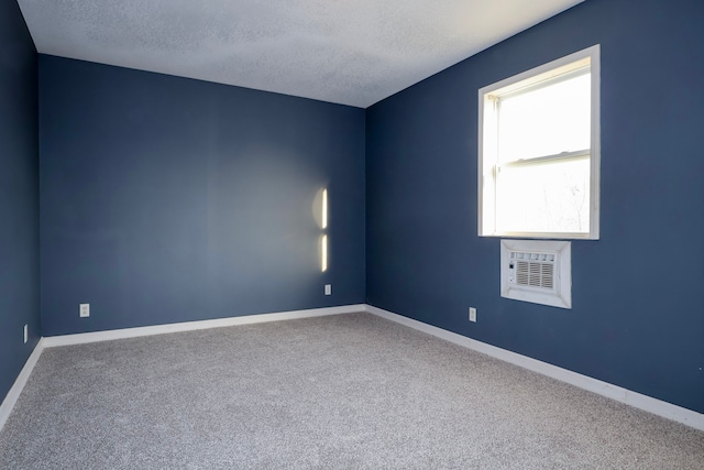 empty room with a textured ceiling, baseboards, and carpet floors