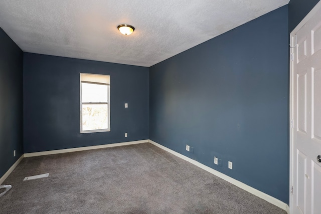 unfurnished room with baseboards, dark colored carpet, and a textured ceiling