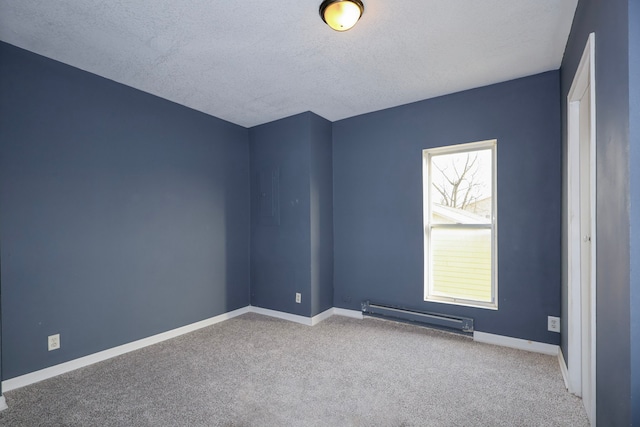 carpeted spare room featuring baseboards, baseboard heating, and a textured ceiling