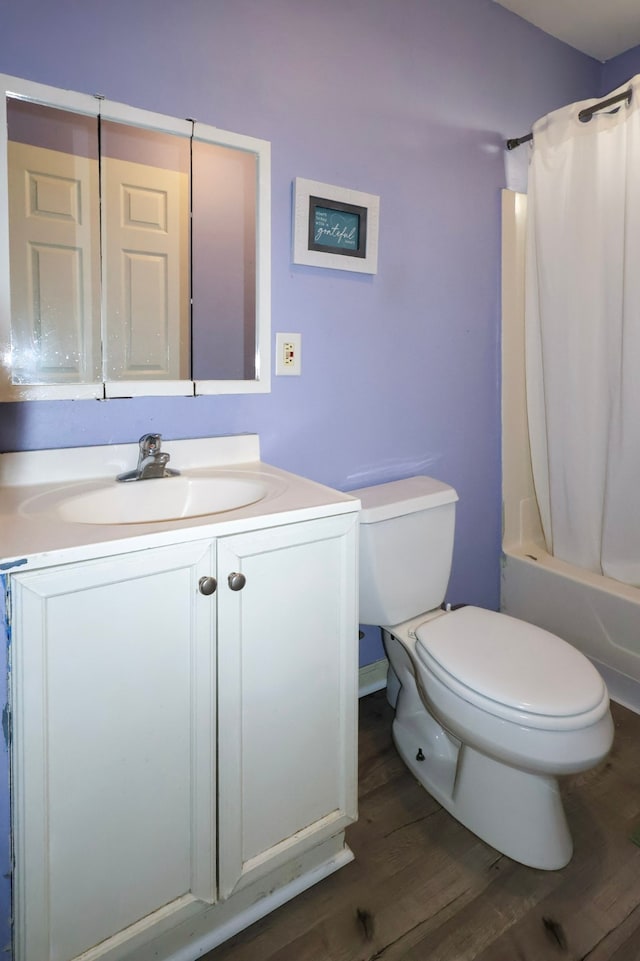 full bathroom featuring toilet, shower / bath combo, wood finished floors, and vanity