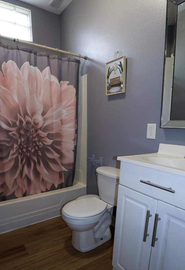 full bathroom featuring visible vents, toilet, shower / tub combo with curtain, wood finished floors, and vanity