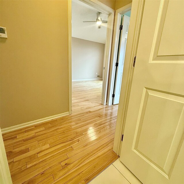 hall with baseboards and light wood finished floors