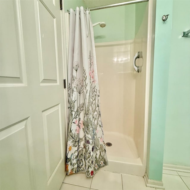 full bathroom with tile patterned floors and a stall shower