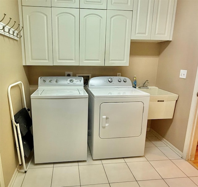 laundry room with light tile patterned flooring, cabinet space, independent washer and dryer, and a sink