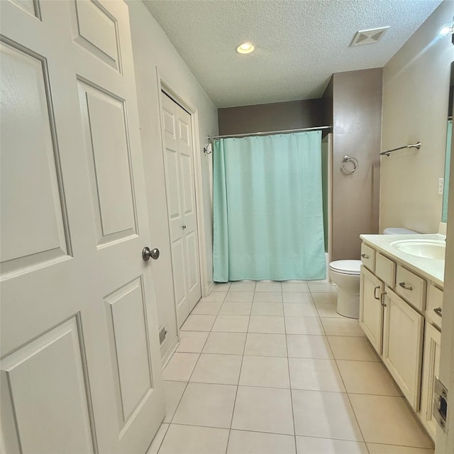 full bathroom featuring tile patterned flooring, visible vents, toilet, vanity, and a textured ceiling