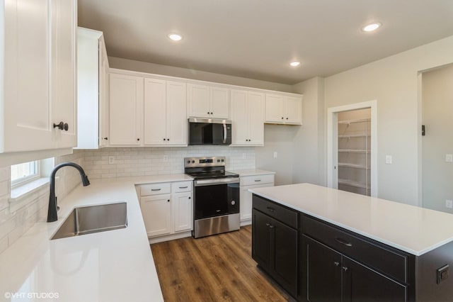 136 Creekside Dr, Bondurant, IA 50035 - kitchen with appliances with stainless steel finishes, dark cabinets, white cabinetry, tasteful backsplash, and recessed lighting