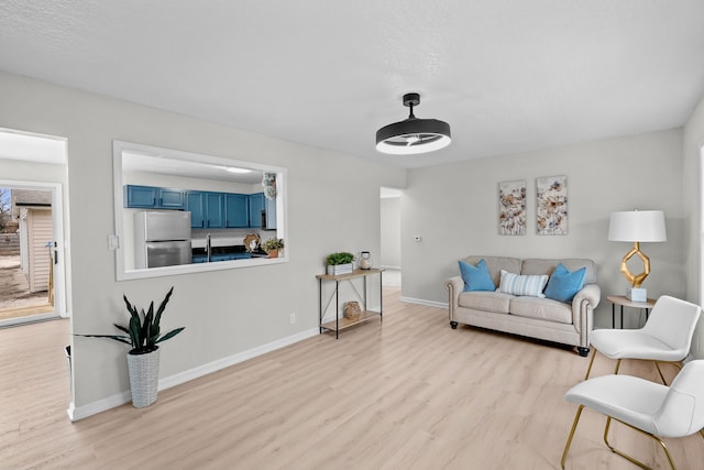 living area featuring baseboards and wood finished floors