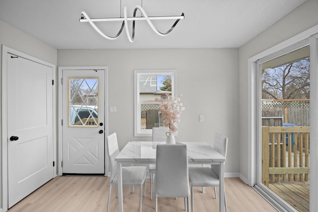 dining room featuring baseboards and light wood-style flooring