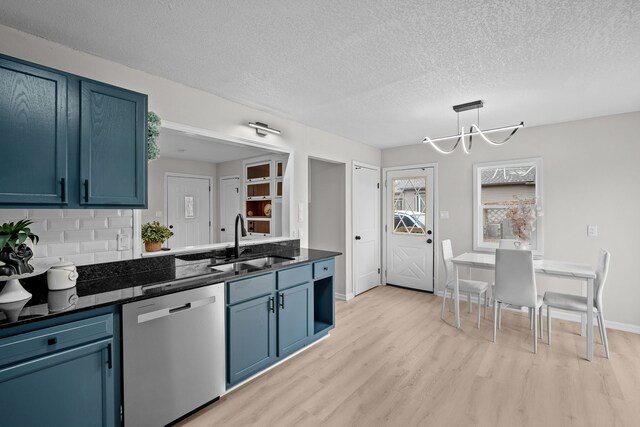 kitchen featuring dark countertops, a sink, blue cabinets, and stainless steel dishwasher