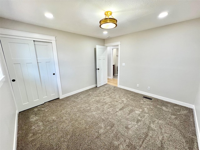 unfurnished bedroom featuring visible vents, baseboards, recessed lighting, a closet, and carpet flooring