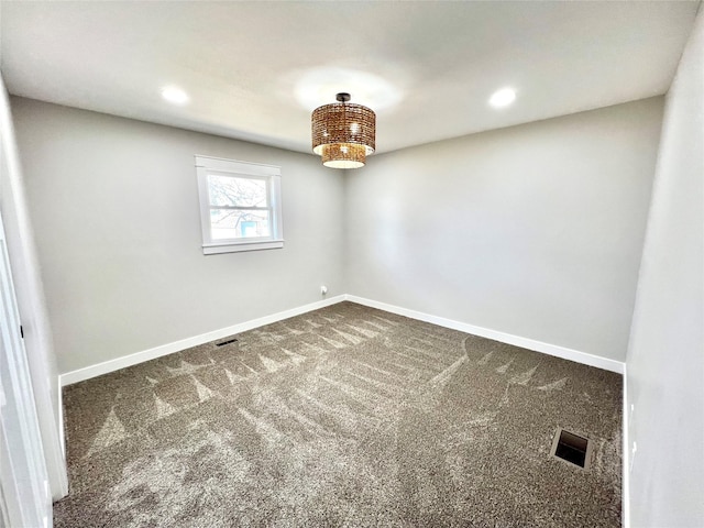 empty room with visible vents, baseboards, and dark carpet