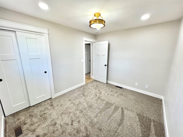 unfurnished bedroom with recessed lighting, visible vents, a closet, baseboards, and carpet flooring