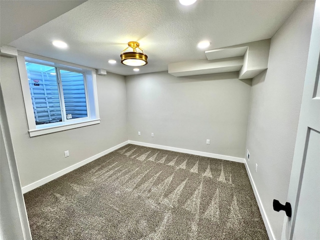 below grade area with baseboards, dark colored carpet, and recessed lighting
