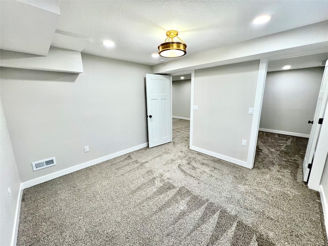 finished basement with baseboards, visible vents, carpet floors, and recessed lighting