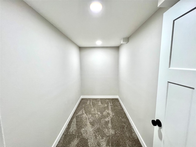 interior space with baseboards and dark colored carpet