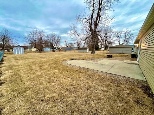 view of yard with a shed, an outdoor structure, a patio, and fence