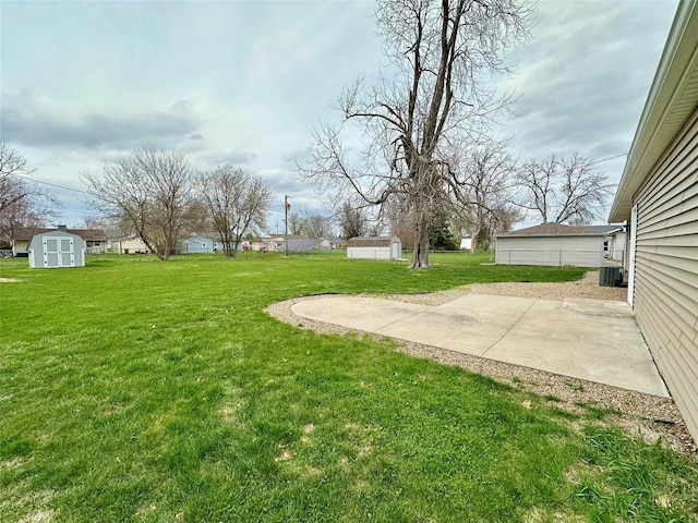 view of yard with central AC unit, an outbuilding, a patio area, and a storage unit