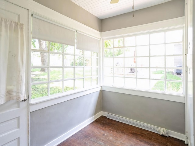 unfurnished sunroom featuring baseboard heating, a healthy amount of sunlight, and ceiling fan