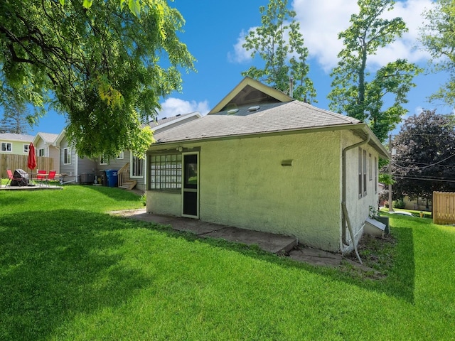 back of house with central air condition unit, stucco siding, fence, a yard, and a patio area