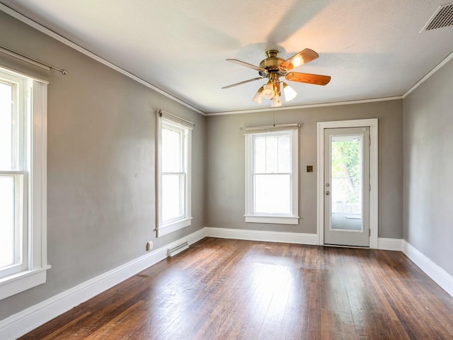 unfurnished room featuring visible vents, a healthy amount of sunlight, dark wood finished floors, and ornamental molding