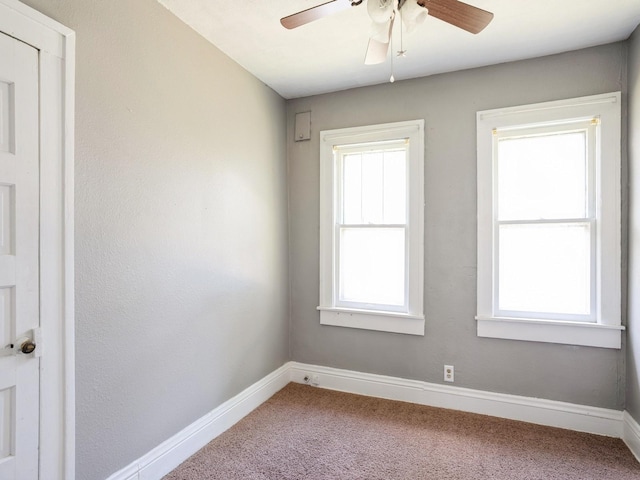 carpeted empty room with ceiling fan and baseboards