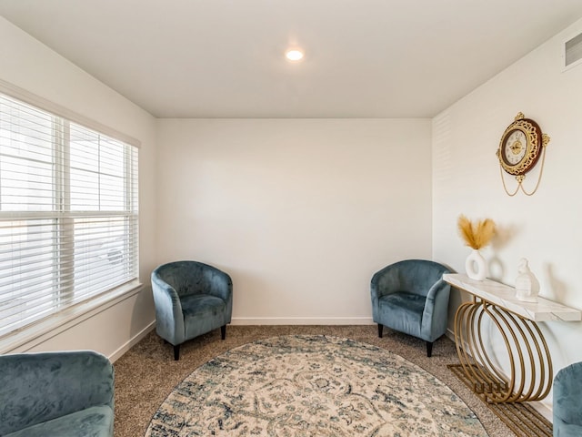 living area featuring visible vents, baseboards, and carpet floors