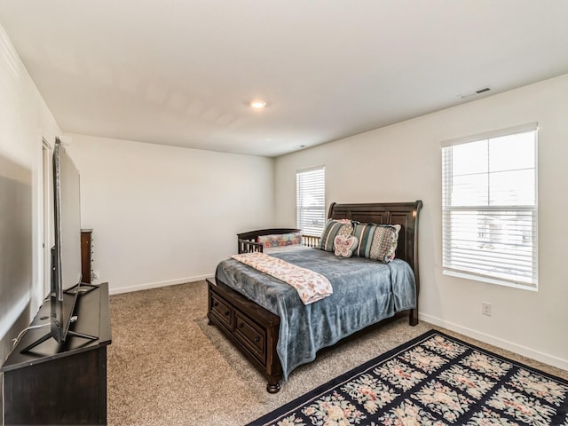 bedroom featuring visible vents, light carpet, and baseboards