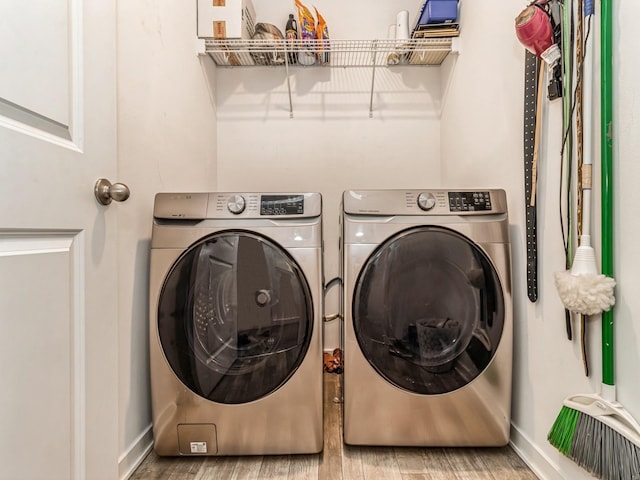 laundry area with laundry area, independent washer and dryer, baseboards, and wood finished floors