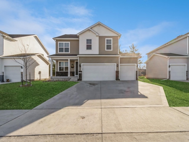 traditional-style house with stone siding, an attached garage, concrete driveway, and a front yard