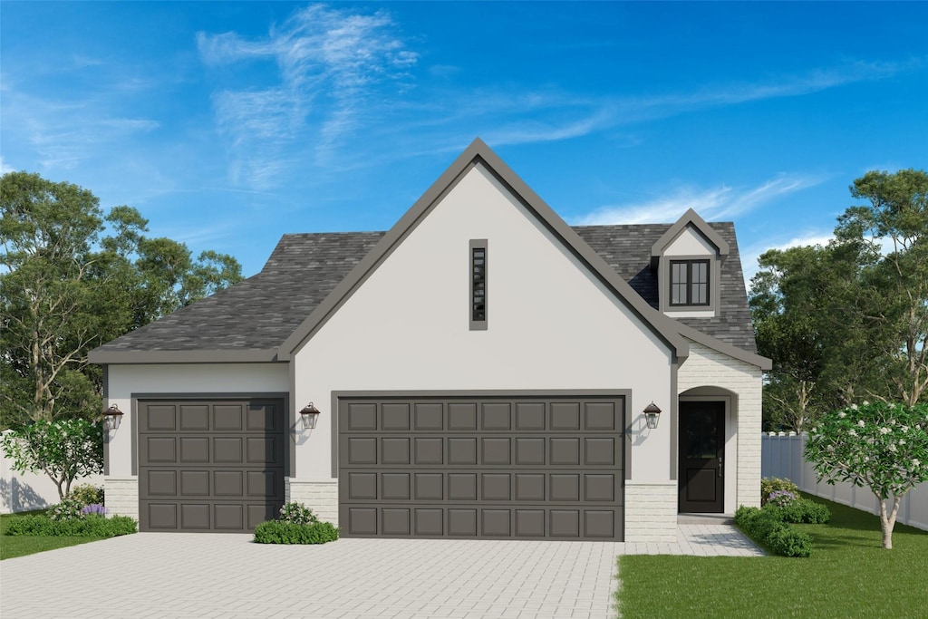 1350 SE Menlo Dr, Waukee, IA 50263 - view of front of house with brick siding, an attached garage, driveway, stucco siding, and roof with shingles