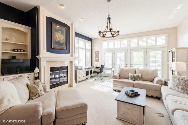 living area featuring an inviting chandelier, a fireplace, and carpet floors