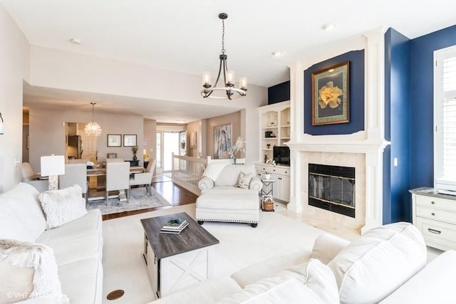 living area featuring an inviting chandelier and a high end fireplace