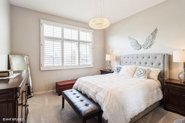 bedroom with light colored carpet and baseboards