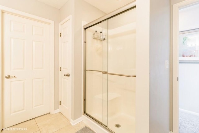 full bathroom with tile patterned flooring, baseboards, and a stall shower