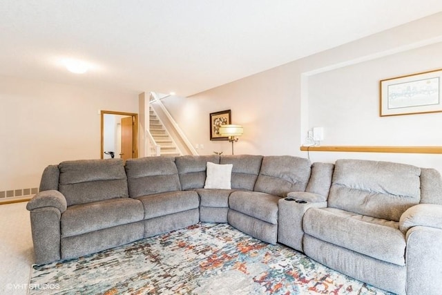 living area featuring visible vents, carpet flooring, and stairs