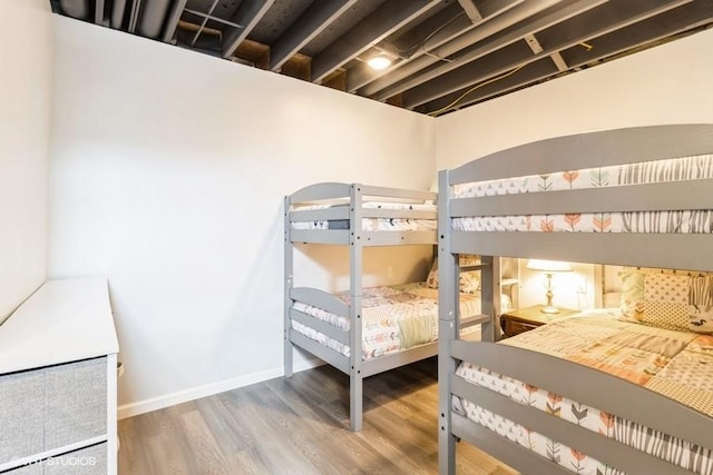 bedroom featuring baseboards and wood finished floors