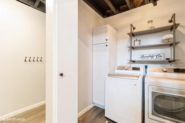 clothes washing area featuring washer and dryer, wood finished floors, and baseboards