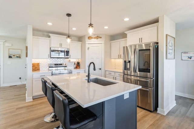 1602 Mulberry St, Granger, IA 50109 - kitchen with appliances with stainless steel finishes, a sink, light wood-style floors, decorative backsplash, and recessed lighting
