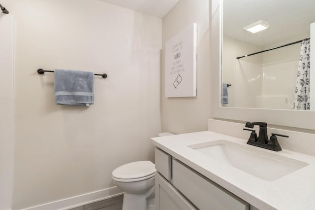 bathroom featuring toilet, vanity, a shower with curtain, baseboards, and wood finished floors